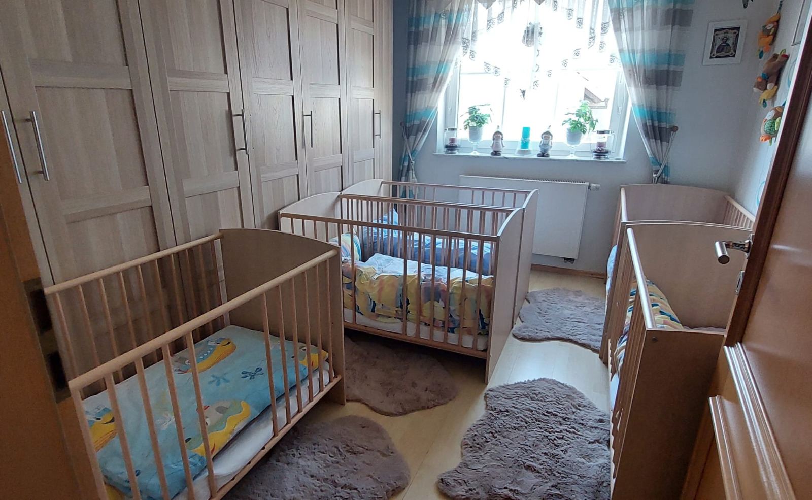 Helles Schlafzimmer mit mehreren niedrigen Kinderbetten und Fell-Teppichen